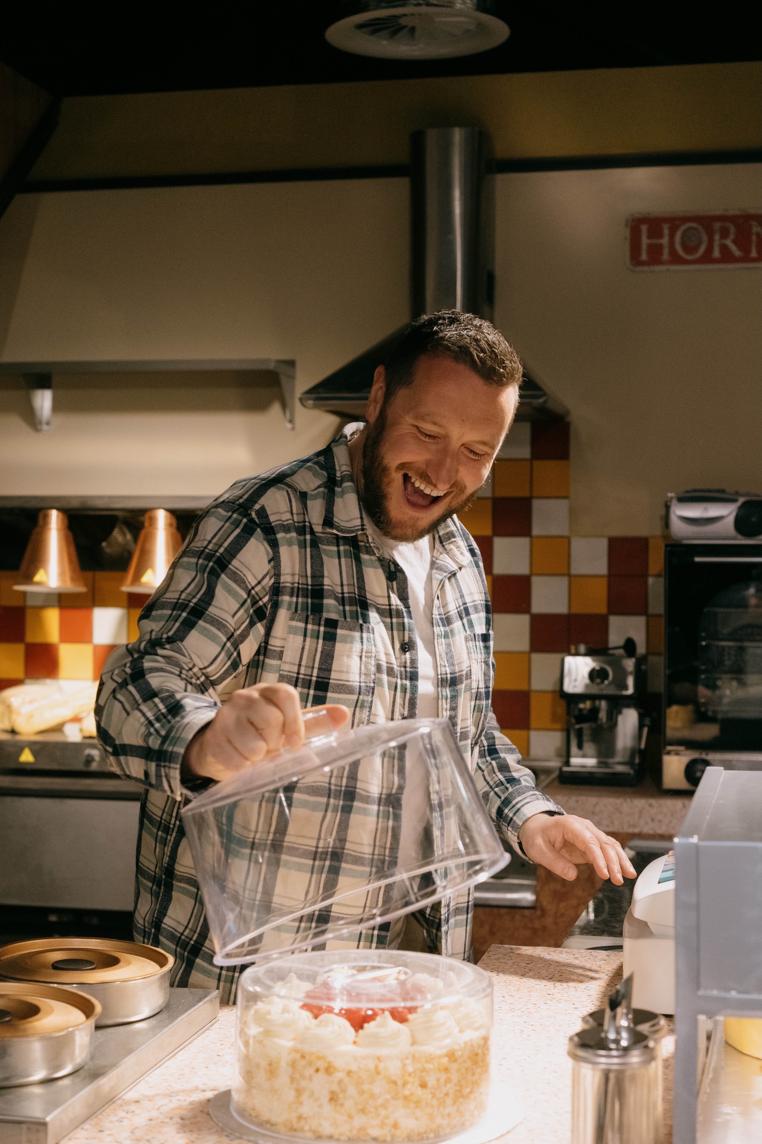 A person opening a cake container at Roy’s Rolls Café at the Coronation Street Experience in Manchester