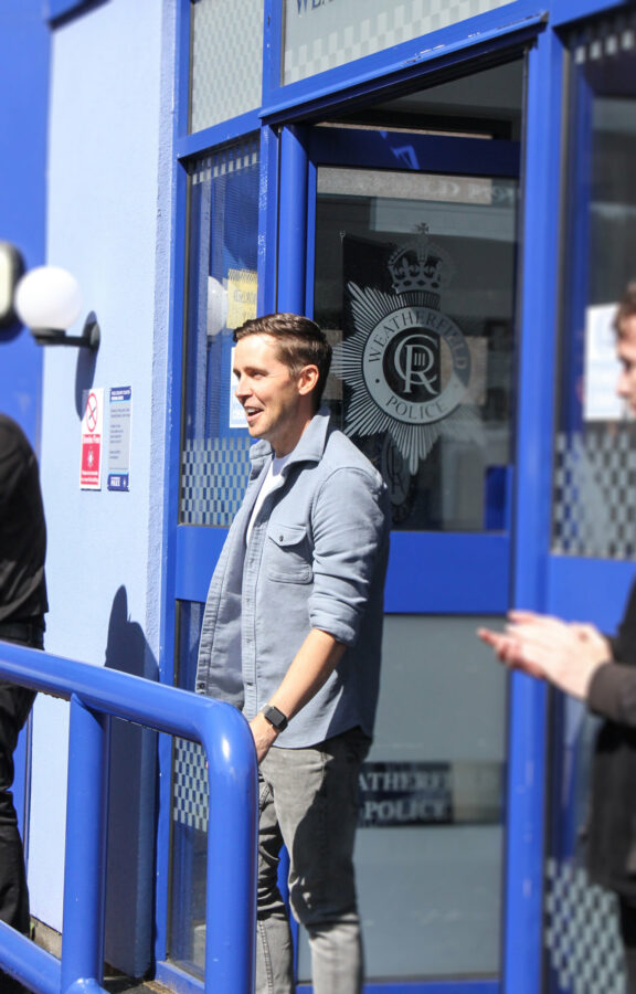 Gareth Pierce, who plays Todd Grimshaw, joking and laughing with the Coronation Street Experience guests outside the Weatherfield police station set.