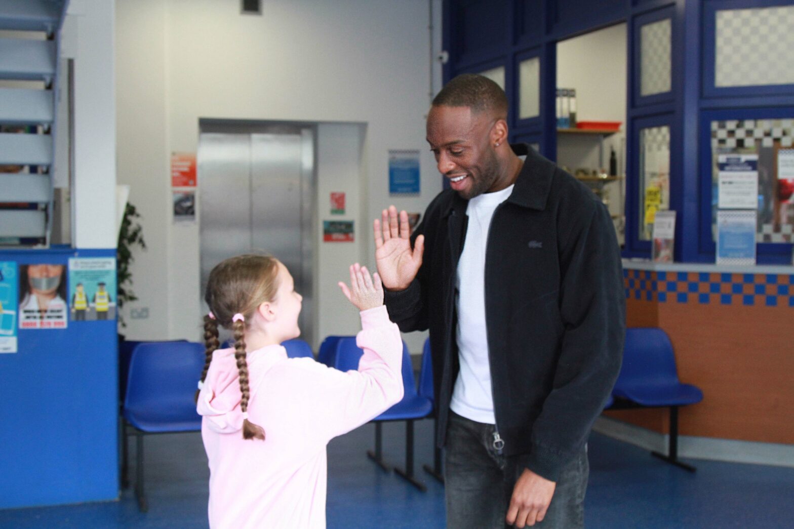 Ryan Russell, who plays Michael Bailey, high fives a child guest at the Coronation Street Experience.