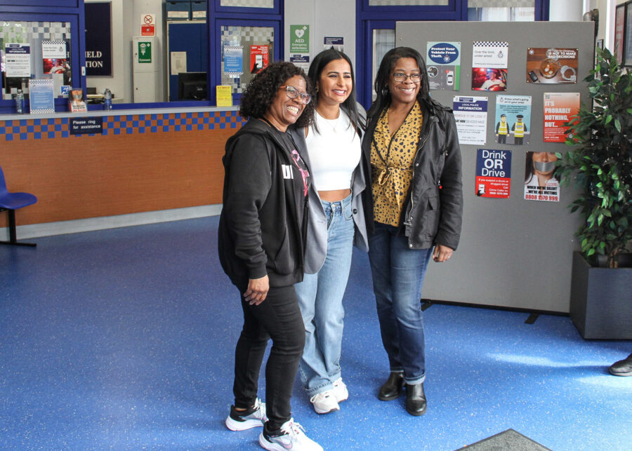 Sair Khan, who plays Alya Nazir, posing for a picture with two guests inside the Weatherfield police station set.