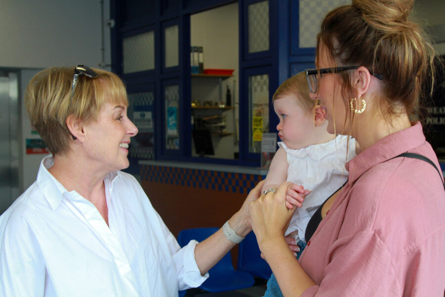 Sally Dynevor at the Coronation Street meet and greet, gently shaking a baby's hand with a warm smile.